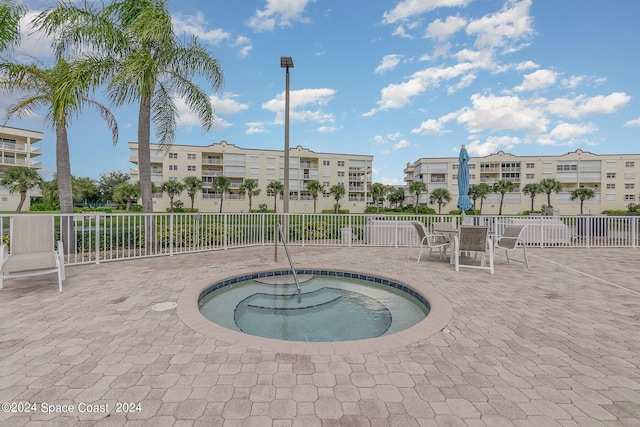 8931 Lake Dr Unit 401, Cape Canaveral, FL 32920 - view of swimming pool featuring a patio area, fence, and a hot tub
