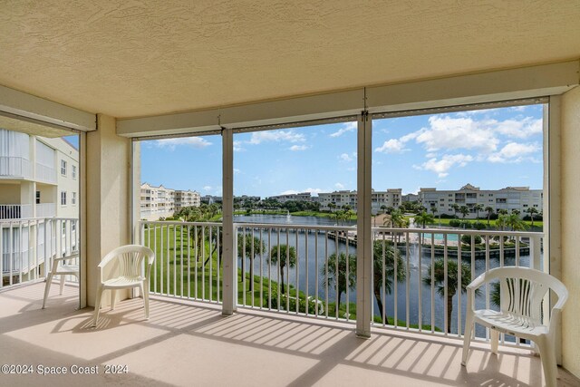 unfurnished sunroom featuring a water view