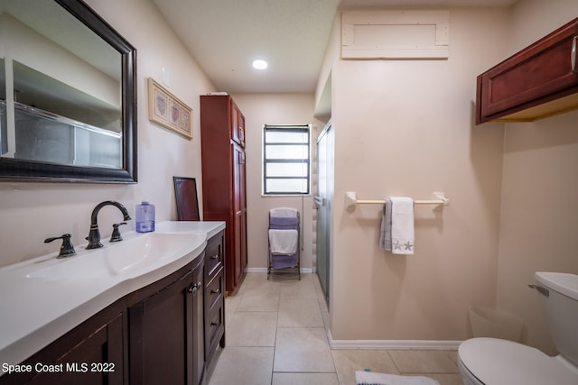 bathroom featuring an AC wall unit, a shower with door, tile patterned floors, vanity, and toilet