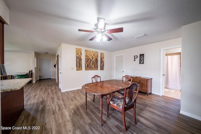 dining room with a textured ceiling, wood-type flooring, and ceiling fan