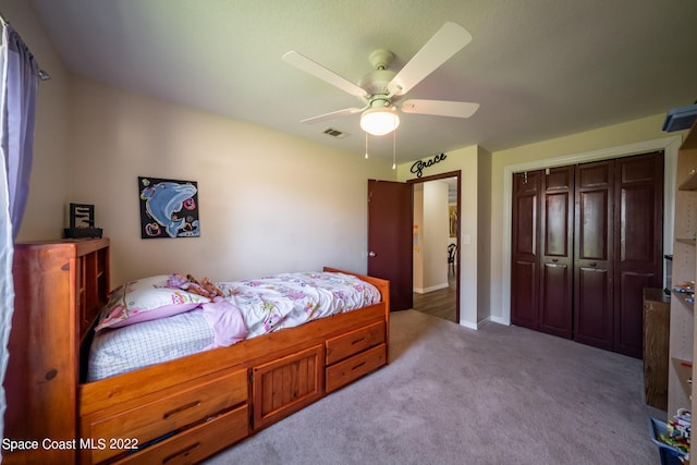 carpeted bedroom featuring ceiling fan and a closet