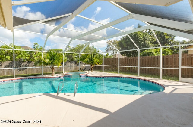 view of swimming pool with a lanai, an in ground hot tub, and a patio area