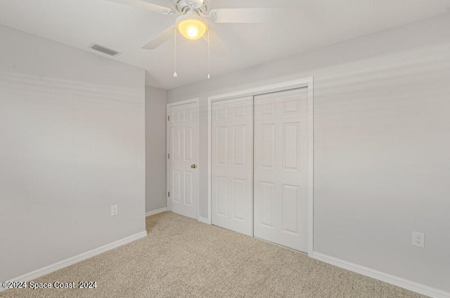 unfurnished bedroom with ceiling fan, a closet, and carpet