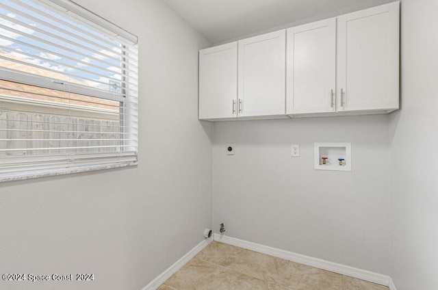 clothes washing area featuring cabinets, electric dryer hookup, hookup for a washing machine, and light tile patterned flooring