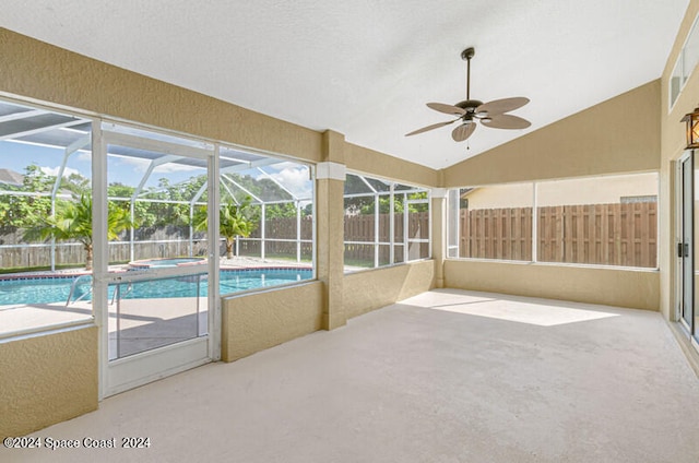 view of swimming pool featuring ceiling fan, glass enclosure, and a patio area