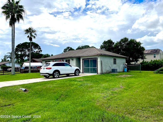 view of front of house featuring central AC unit and a front lawn