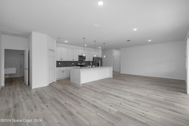 kitchen with stainless steel appliances, open floor plan, recessed lighting, and white cabinets