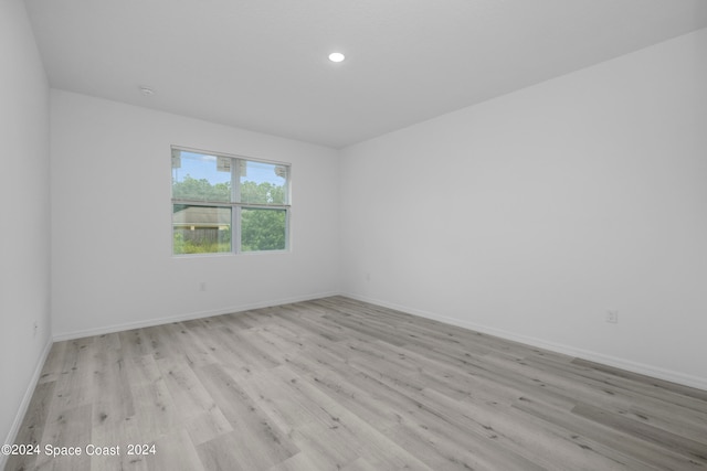 empty room with baseboards, recessed lighting, and wood finished floors
