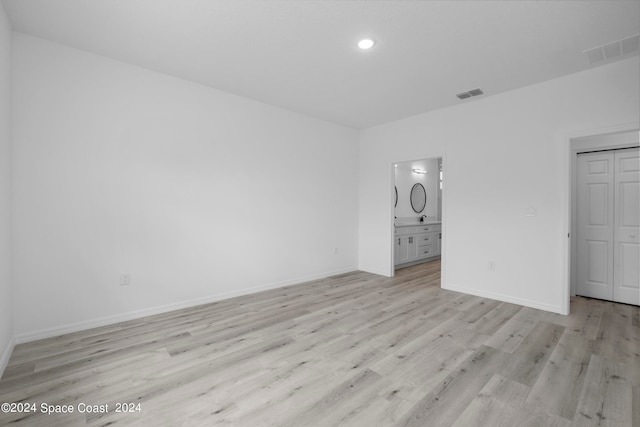 unfurnished bedroom with light wood-type flooring, visible vents, and baseboards
