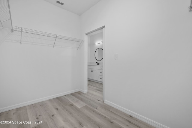 spacious closet with light wood-style floors and visible vents