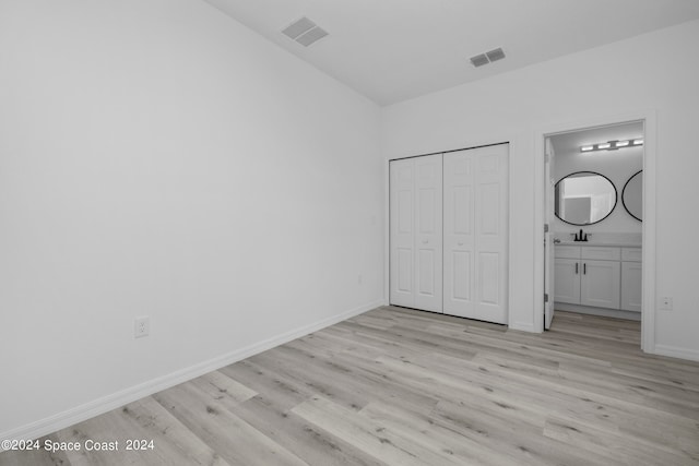 unfurnished bedroom with baseboards, a closet, light wood finished floors, and visible vents