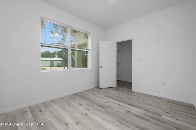 unfurnished room with wood finished floors and baseboards