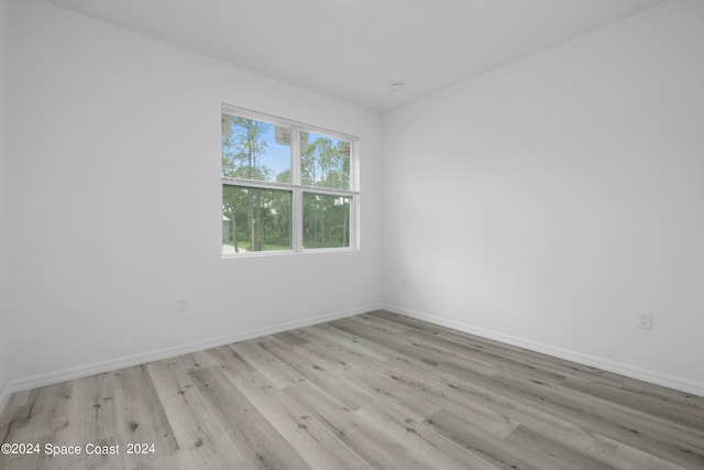 unfurnished room with baseboards and wood finished floors