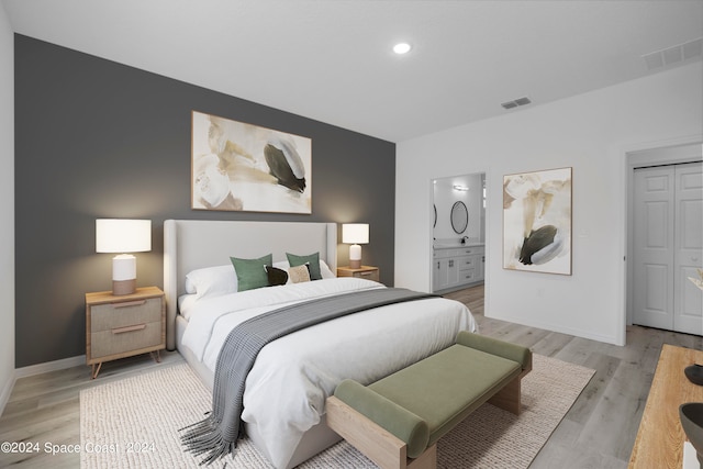 bedroom with light wood-style floors, visible vents, and baseboards