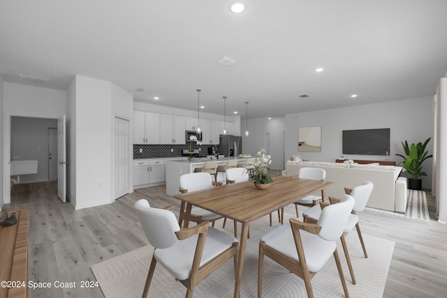 dining area with light wood-style flooring, baseboards, and recessed lighting