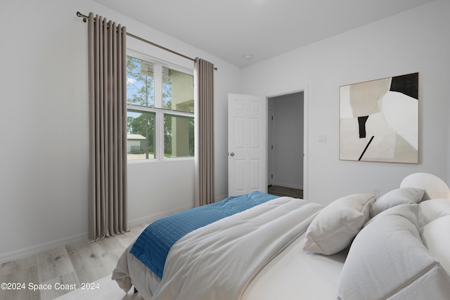 bedroom featuring light wood-style floors and baseboards