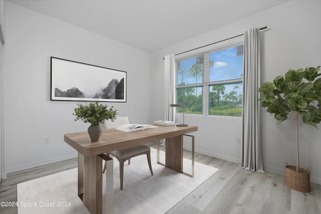office space with baseboards and light wood-style floors