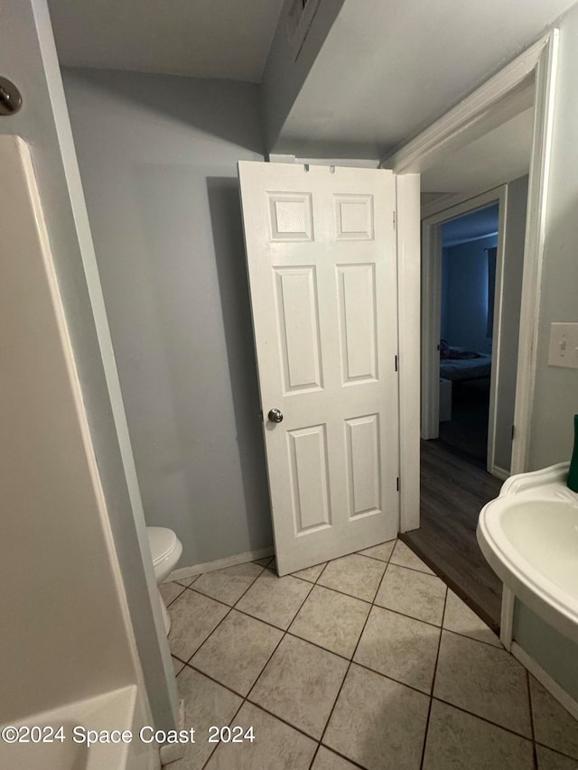 bathroom with toilet and tile patterned floors