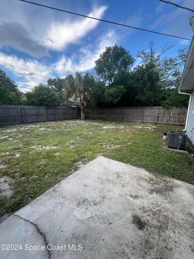 view of yard featuring central air condition unit and a patio