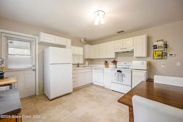 kitchen with a textured ceiling, white appliances, light tile patterned floors, and white cabinets