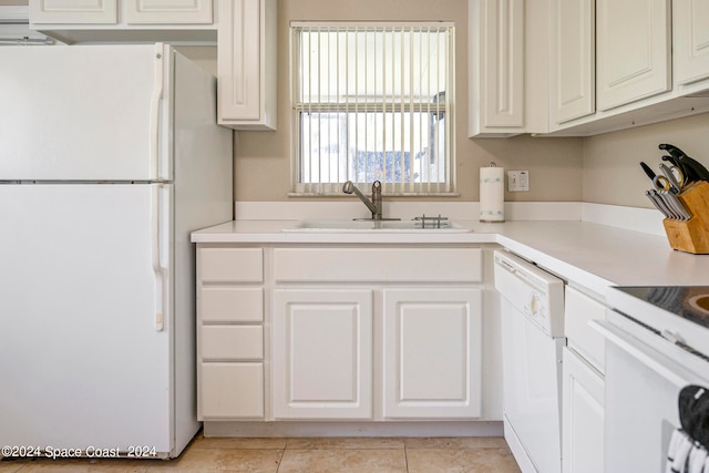 kitchen with white appliances, sink, light tile patterned floors, and white cabinets