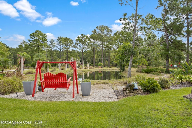 view of jungle gym featuring a water view and a yard