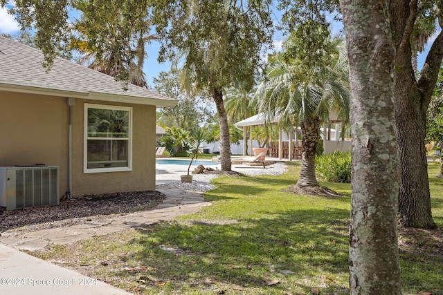 view of yard featuring a fenced in pool, a patio area, and central AC