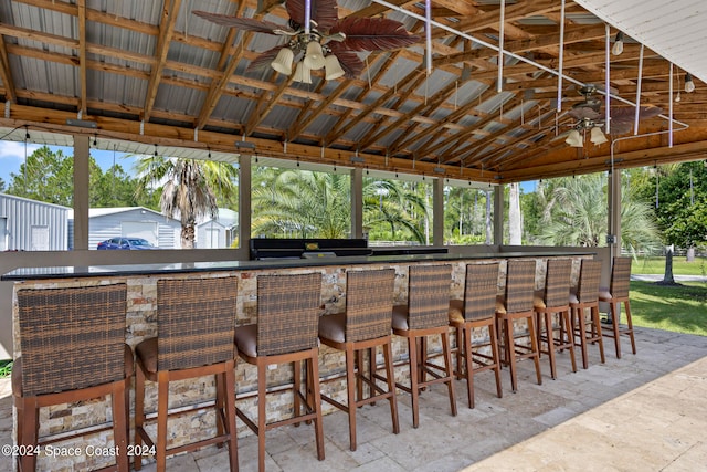 view of patio with exterior bar and ceiling fan