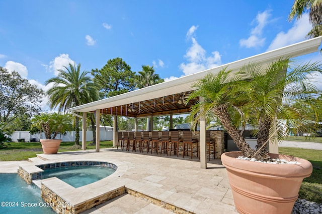 view of swimming pool with an in ground hot tub, exterior bar, a gazebo, a patio area, and pool water feature