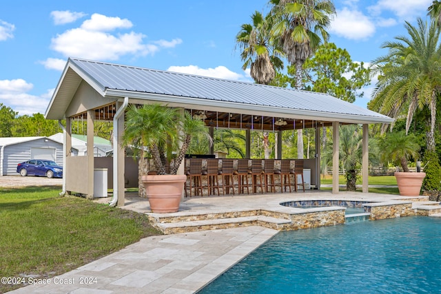 view of swimming pool with exterior bar, a gazebo, an in ground hot tub, and a patio area