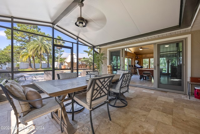 sunroom with ceiling fan, vaulted ceiling, and a healthy amount of sunlight