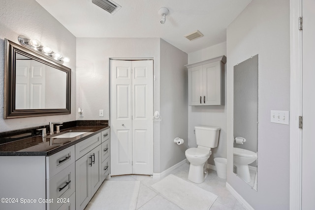 bathroom featuring tile patterned flooring, vanity, and toilet