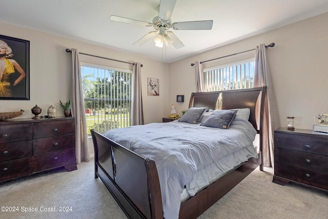 carpeted bedroom with multiple windows, access to outside, and ceiling fan