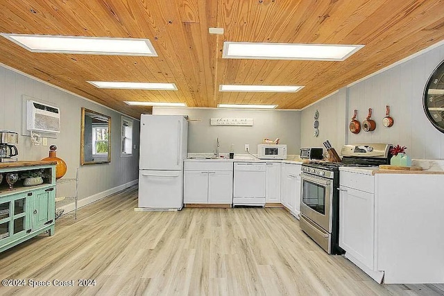 kitchen featuring white cabinets, white appliances, wooden walls, light hardwood / wood-style flooring, and an AC wall unit