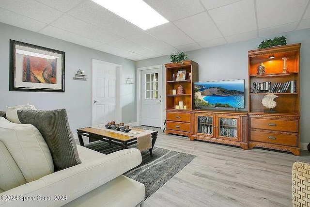 living room with a paneled ceiling and light hardwood / wood-style flooring