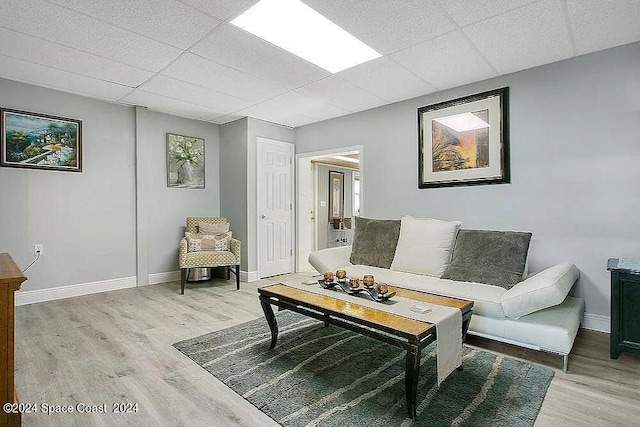 living room featuring hardwood / wood-style flooring and a paneled ceiling