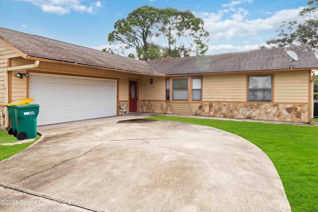 single story home with a garage and a front lawn