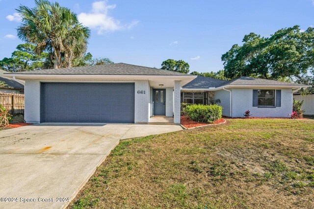 single story home featuring a garage and a front yard