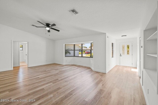 unfurnished living room featuring a textured ceiling, ceiling fan, and light hardwood / wood-style flooring