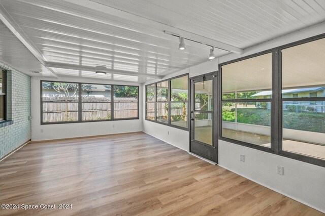 unfurnished sunroom featuring rail lighting