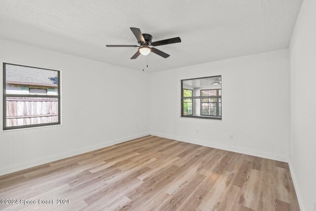 unfurnished room with a textured ceiling, ceiling fan, and light hardwood / wood-style flooring