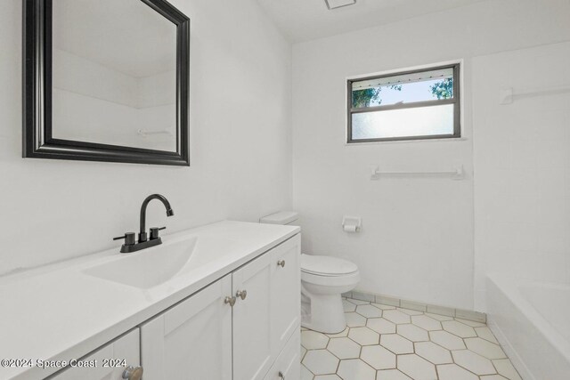 full bathroom with vanity, toilet,  shower combination, and tile patterned floors