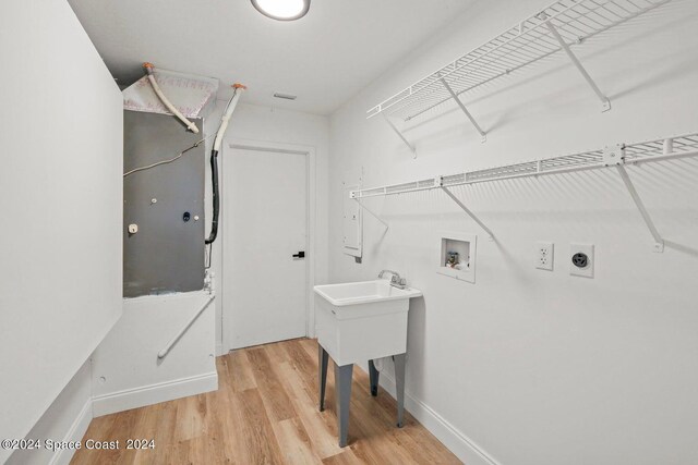 clothes washing area featuring hookup for an electric dryer, washer hookup, and hardwood / wood-style flooring