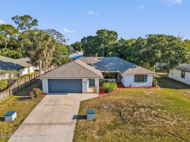 single story home with a garage and a front lawn