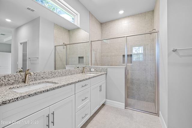 bathroom featuring vanity, tile patterned flooring, and a shower with door