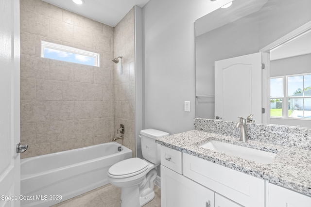 full bathroom featuring tiled shower / bath combo, plenty of natural light, vanity, and toilet