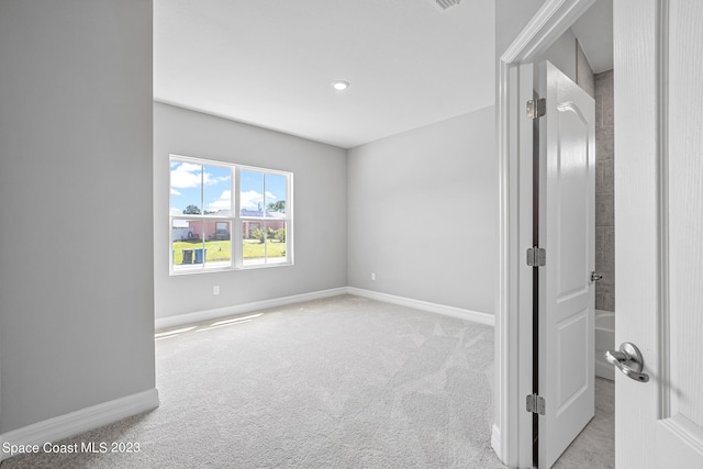 spare room featuring light colored carpet