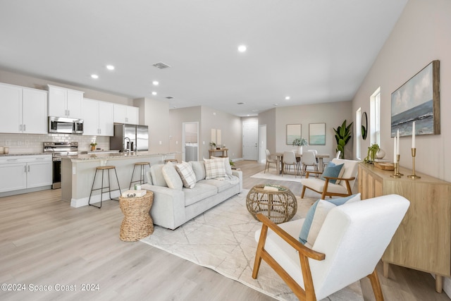 living room featuring light wood-type flooring and sink