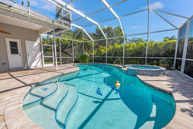 view of swimming pool featuring an in ground hot tub, a patio, and a lanai