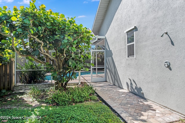 view of yard with glass enclosure and a patio area